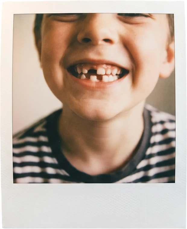 Polaroid of a child with a gap-toothed grin